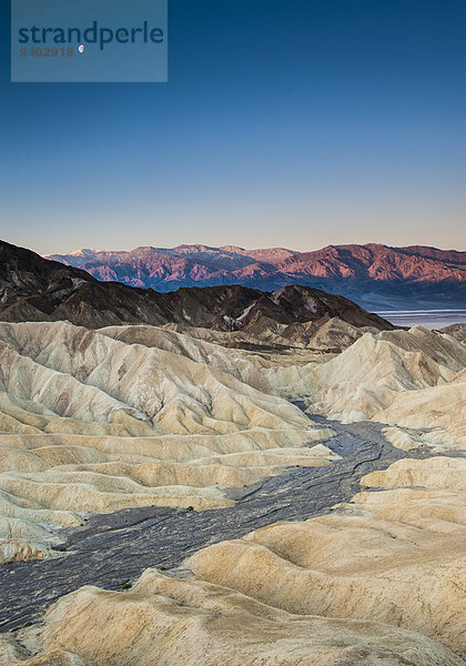 Vereinigte Staaten von Amerika USA blauer Himmel wolkenloser Himmel wolkenlos Felsformation Nationalpark Hochformat Außenaufnahme Landschaftlich schön landschaftlich reizvoll Berg Tag Ruhe Landschaft Schönheit Sonnenaufgang niemand Reise Natur Mond Sonnenlicht Horizont Erosion Death Valley Nationalpark Kalifornien Idylle freie Natur