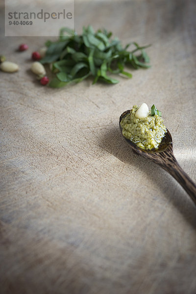 Bärlauch-Pesto und Pinienkern auf einem Holzlöffel