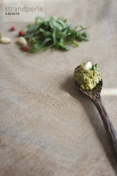 Bärlauch-Pesto und Pinienkern auf einem Holzlöffel