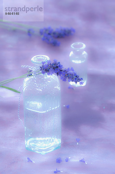 Lavendelblüte und Lavendelwasser in einer Glasflasche