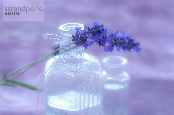 Lavendelblüte und Lavendelwasser in einer Glasflasche