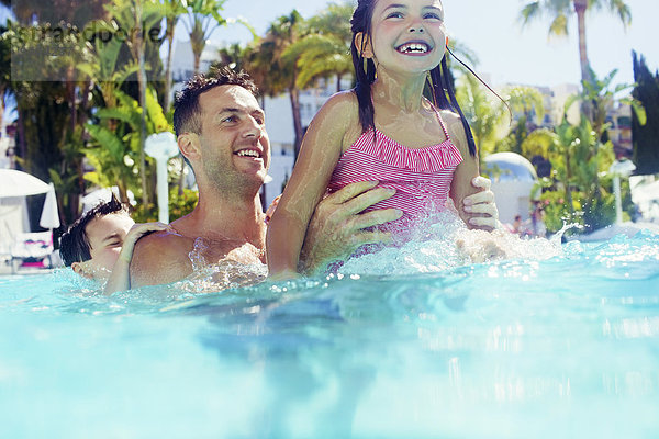 Vater mit Tochter und Sohn beim Spielen im Schwimmbad