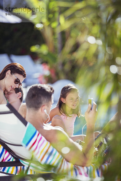 Familie mit zwei Kindern beim Sonnenbaden am Kurschwimmbad