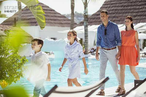 Familie mit zwei Kindern beim gemeinsamen Spaziergang am Schwimmbad