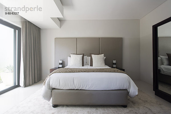 Modernes weißes und beiges Schlafzimmer mit Doppelbett
