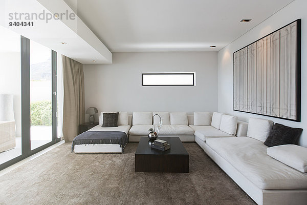 Blick ins moderne Wohnzimmer mit Sofas  Couchtisch und abstrakter Malerei