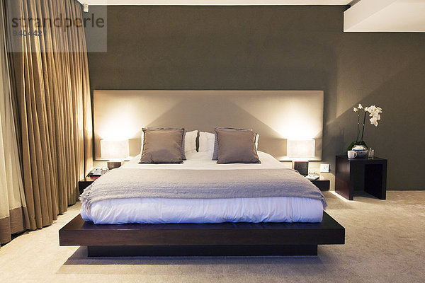 Modernes Schlafzimmer mit Doppelbett bei Nacht beleuchtet
