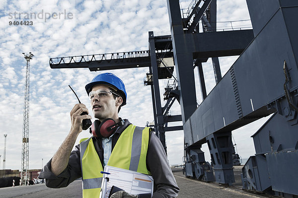 Arbeiter mit Walkie-Talkie am Kran