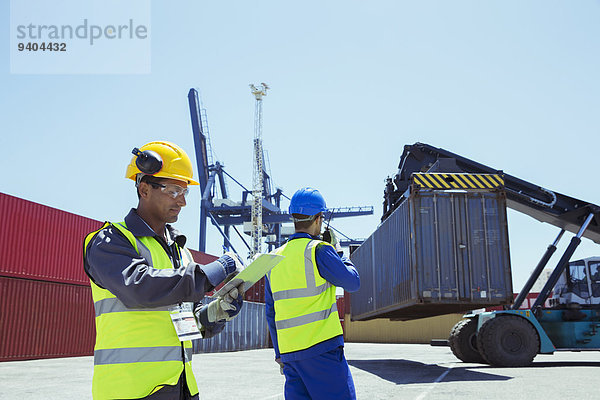 Arbeiter in der Nähe von Frachtcontainern