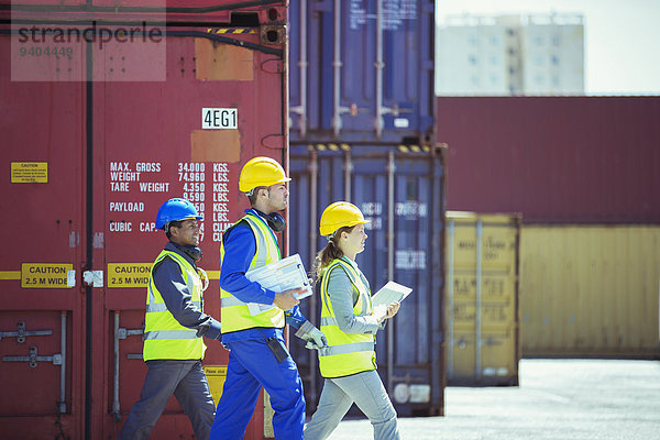 Geschäftsleute und Arbeiter in der Nähe von Frachtcontainern