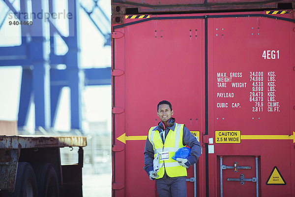 Arbeiter lächelt in der Nähe des Frachtcontainers