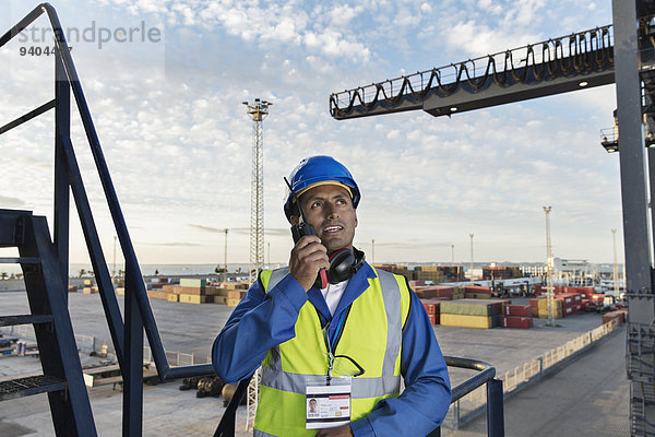 Arbeiter mit Walkie-Talkie am Ladekran