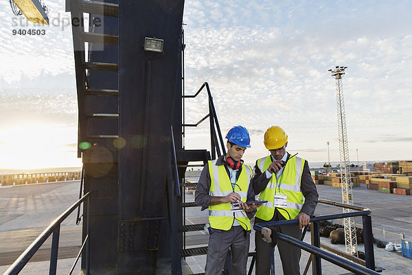 Arbeiter mit Walkie-Talkie am Ladekran