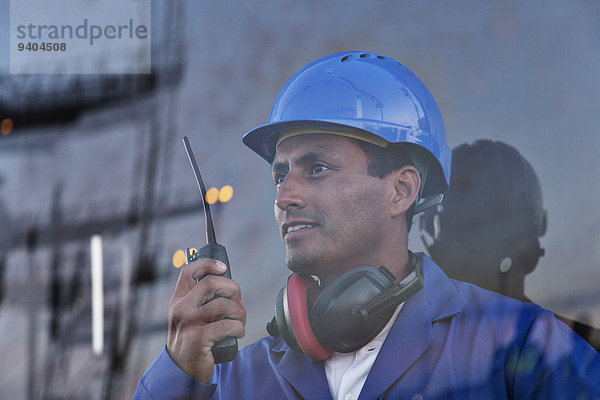 Arbeiter hält Walkie-Talkie in der Nähe des Fensters