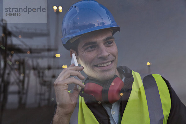 Arbeiter spricht am Handy in der Nähe des Fensters