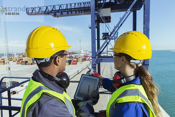 Arbeiter mit digitalem Tablett am Ladekran