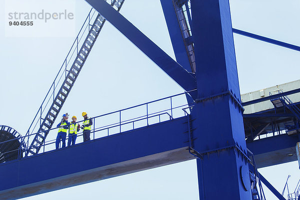 Niederwinkelansicht der Arbeiter am Ladekran