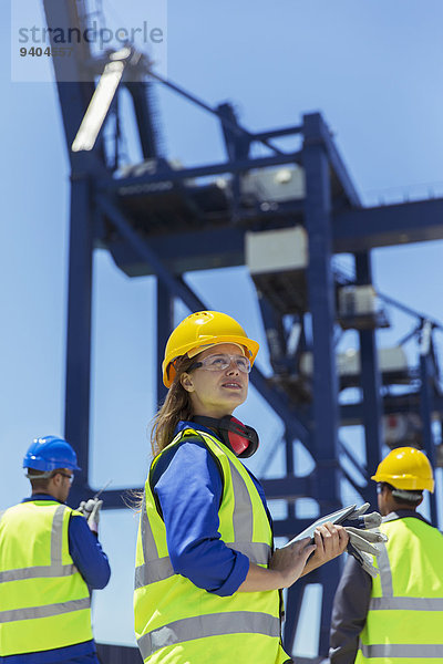 Niedriger Blickwinkel des Arbeiters in der Nähe des Ladekranes