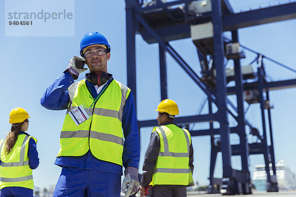 Arbeiter mit Walkie-Talkie am Ladekran