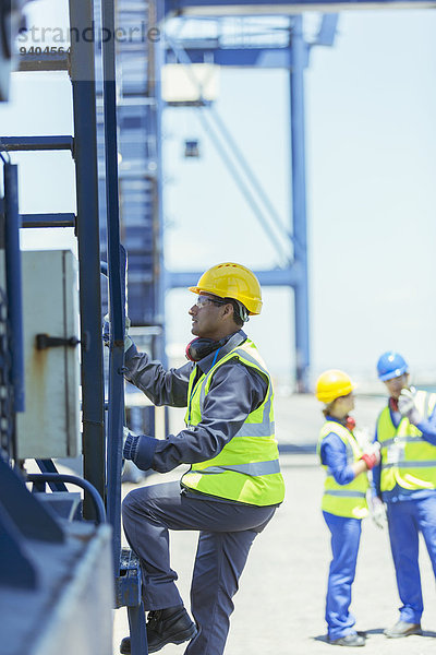 Arbeiter klettert auf den Ladekran