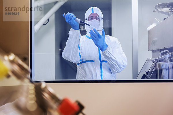 Wissenschaftler im Clean Suit Pipettieren der Probe in die Petrischale im Labor