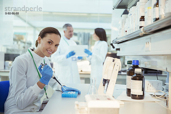 Wissenschaftler pipettieren Proben in den Tray im Labor