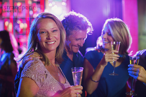 Freunde mit Champagnerflöten haben Spaß im Nachtclub