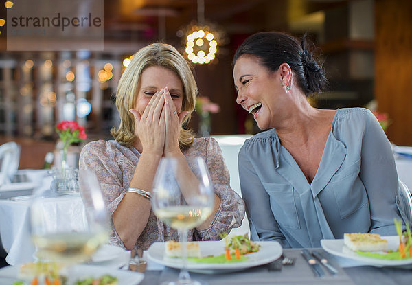 Zwei reife Frauen lachen im Restaurant