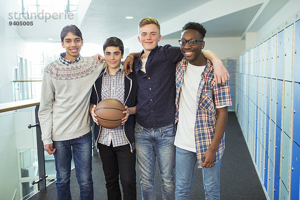 Gruppenporträt männlicher Schüler mit Basketball im Schulflur