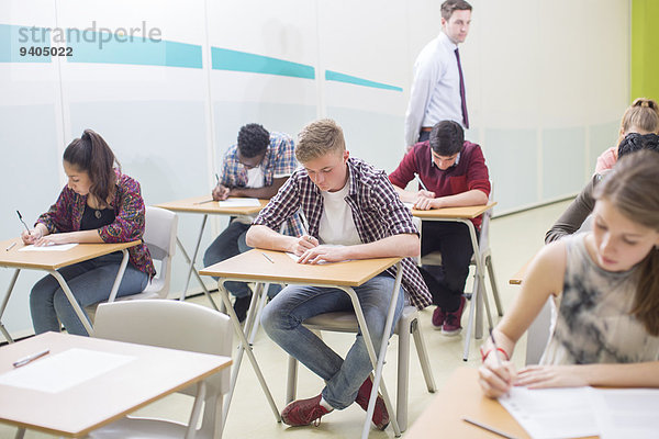 Schüler  die ihre GCSE-Prüfung im Klassenzimmer schreiben