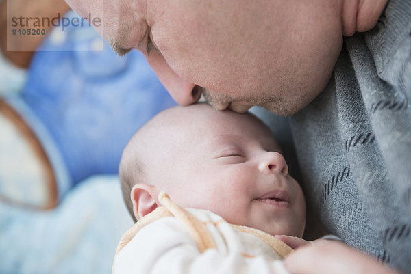 Father kissing his sleeping son  close up