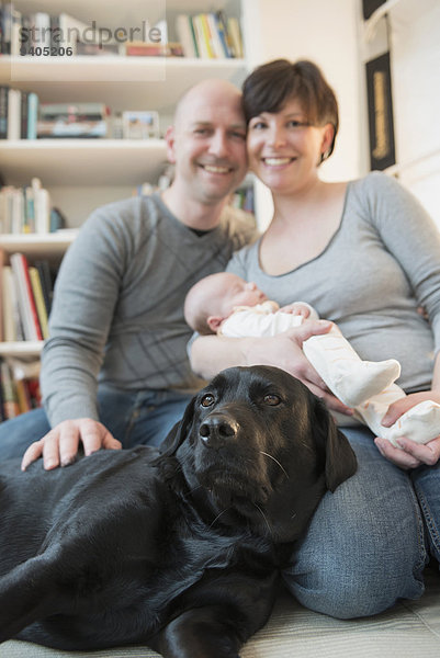 Portrait of family with baby boy and dog  smiling