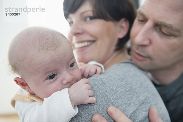 Family holding baby boy  smiling  close up
