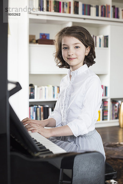 Portrait of girl playing piano  smiling