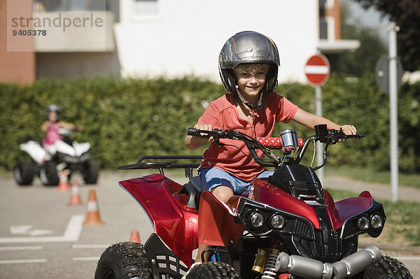 Smiling boy with quadbike on driver training area