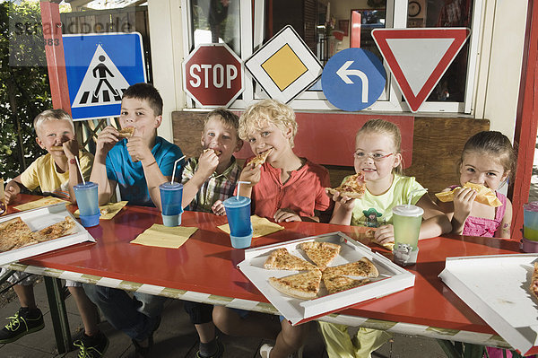 Children eating pizza at driver training area