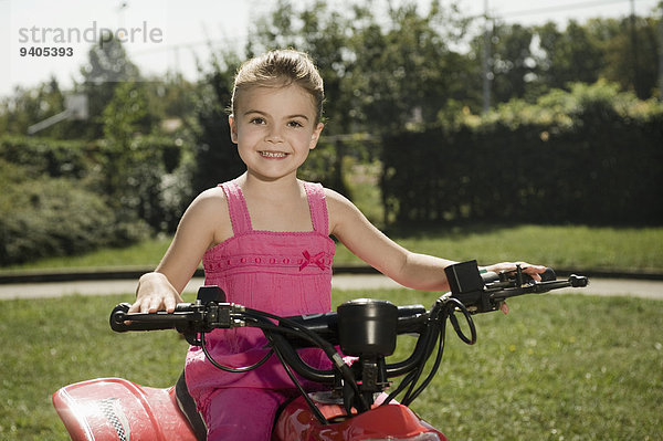 Smiling girl with quadbike on driver training area
