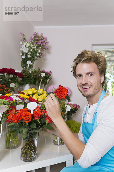 Portrait Mann Blume lächeln arrangieren Mittelpunkt Blumenvase Erwachsener