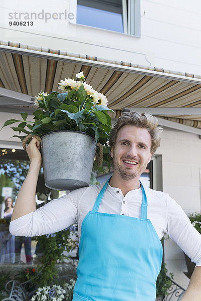 Portrait Mann Blume lächeln halten Pflanze Mittelpunkt Topfpflanze Erwachsener