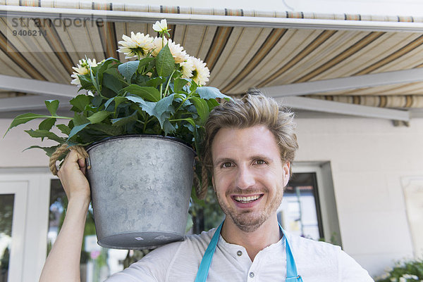 Portrait Mann Blume lächeln halten Pflanze Mittelpunkt Topfpflanze Erwachsener