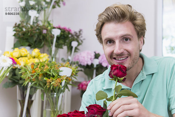 Portrait Mann lächeln halten Mittelpunkt rot Erwachsener Rose
