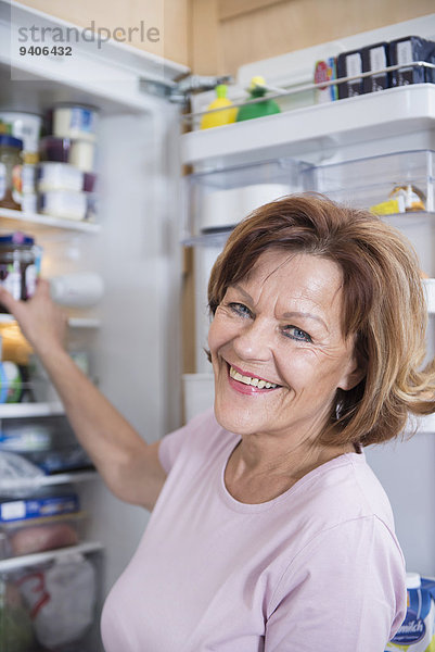 Senior Senioren Portrait Frau lächeln offen Kühlschrank