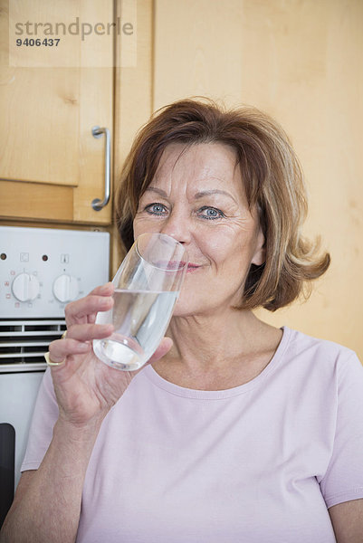 Senior Senioren Wasser Portrait Frau Glas lächeln Küche