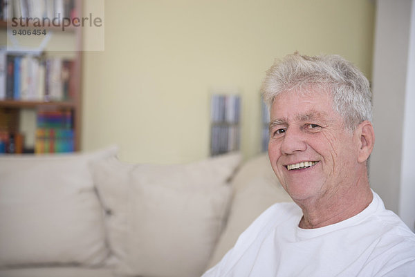 sitzend Senior Senioren Portrait Mann lächeln Couch