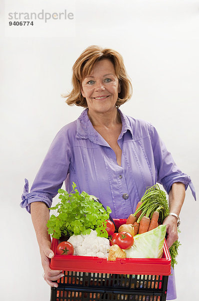 Senior Senioren Portrait Frau lächeln Korb Gemüse