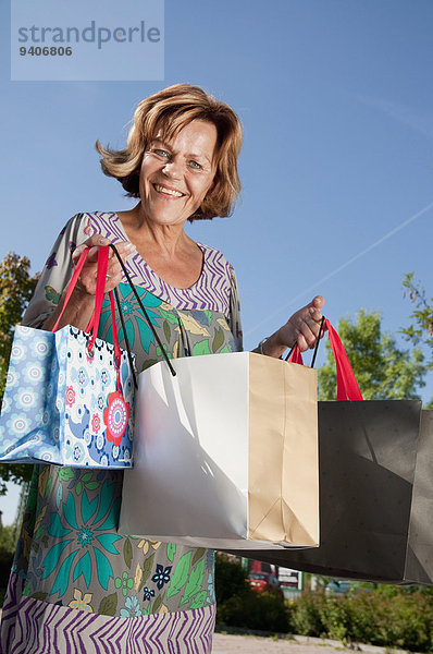 Senior Senioren Portrait Frau lächeln Tasche halten kaufen