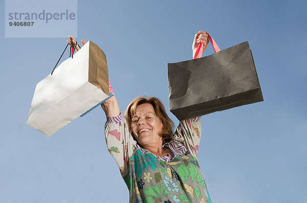 Senior Senioren Portrait Frau lächeln heben Tasche kaufen