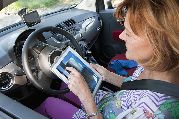 sitzend Senior Senioren benutzen Frau Auto Tablet PC