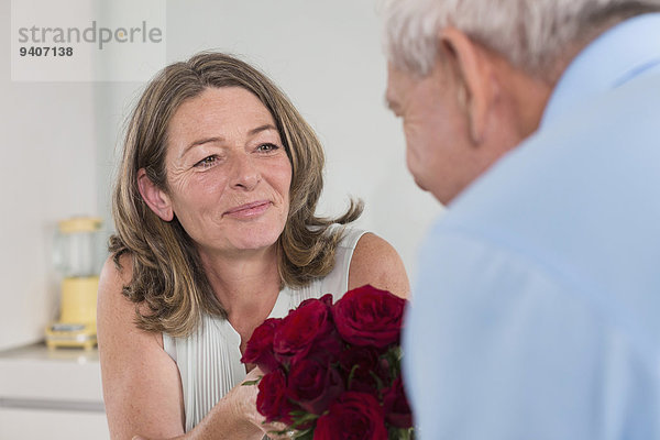 Senior Senioren Frau Mann geben rot Rose