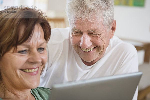 Senior Senioren benutzen lächeln Tablet PC